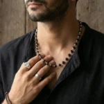 boy wearing karungali malai with silver cap